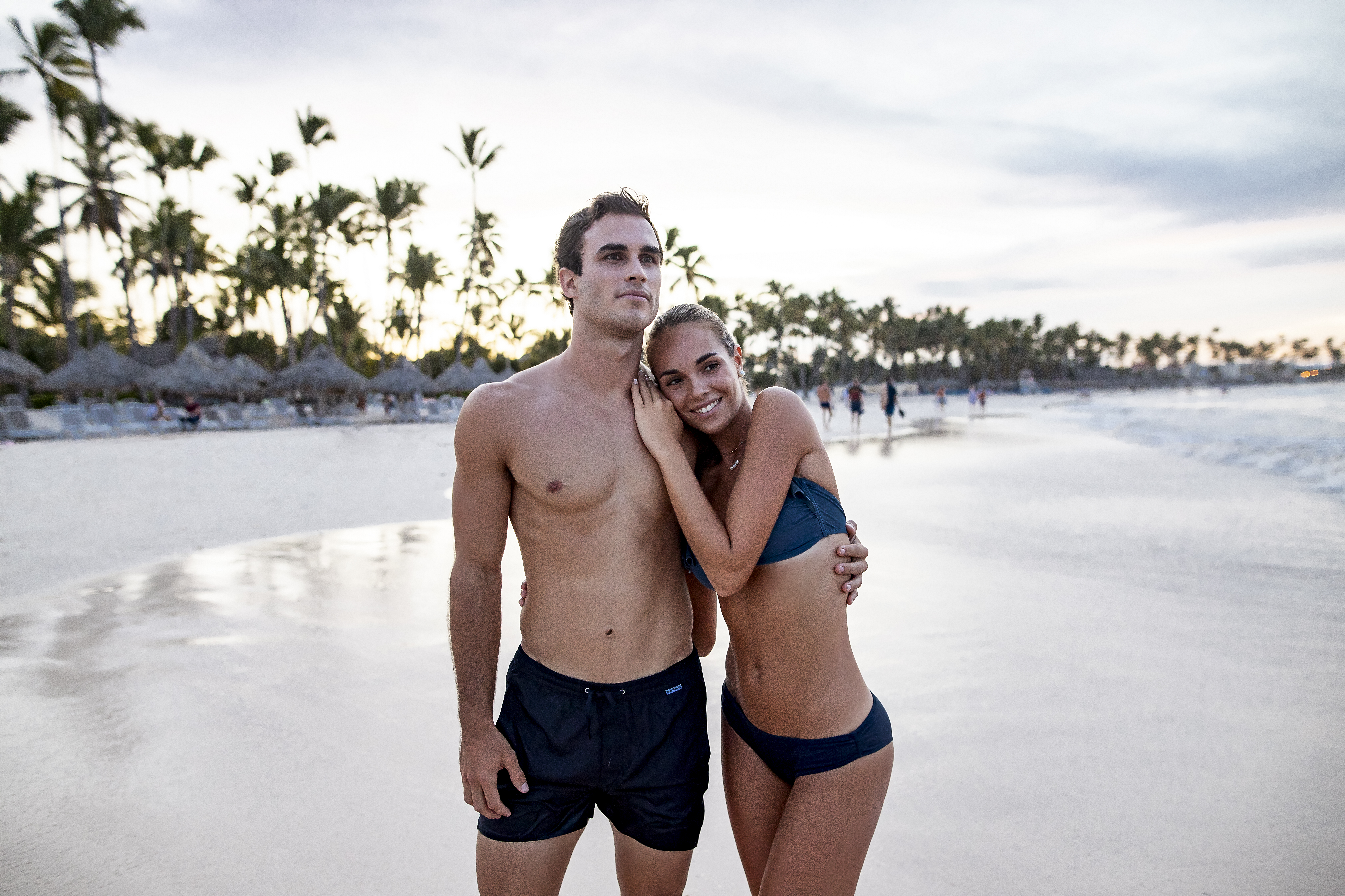 a man and woman posing for a picture on a beach
