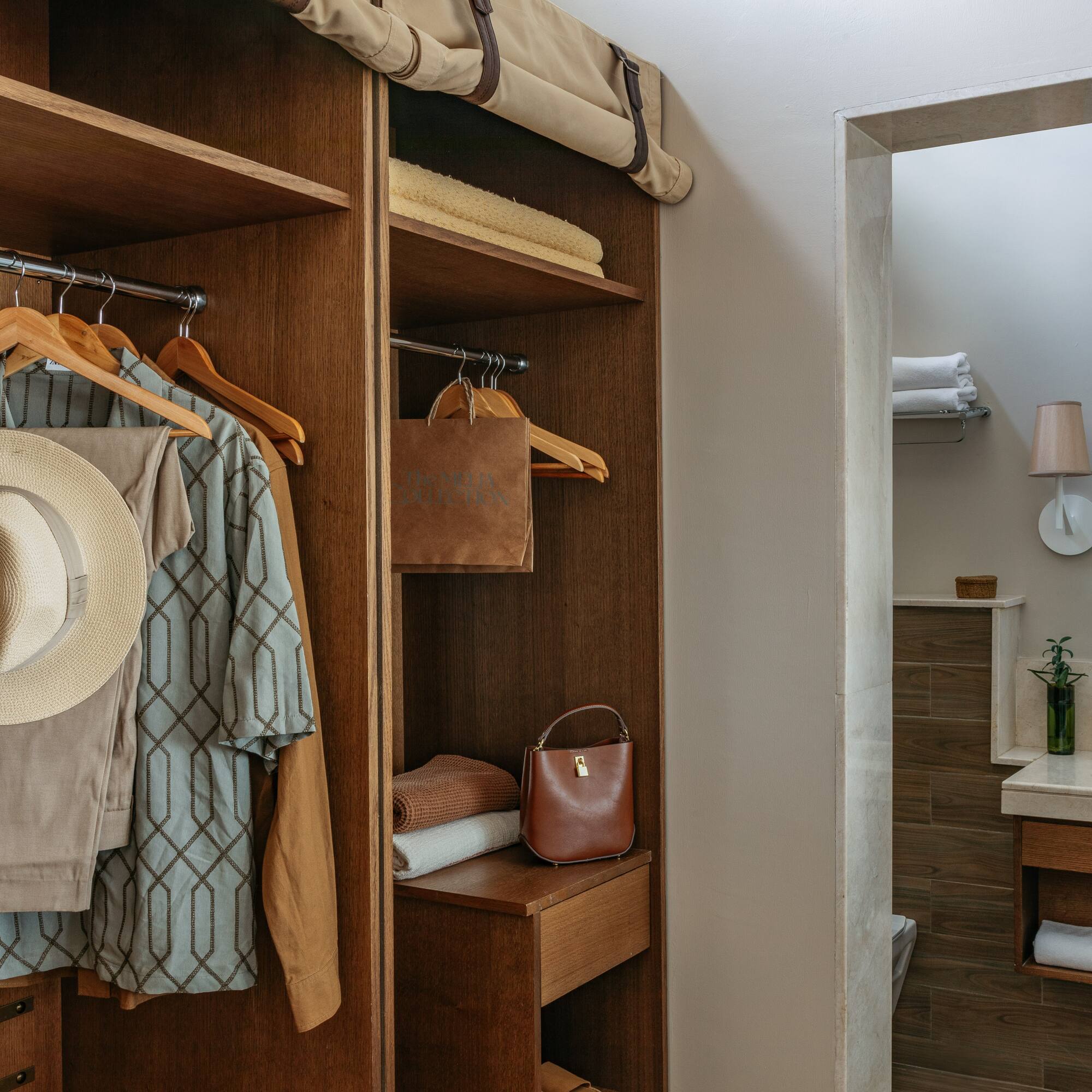 a closet with clothes on swingers and a bag