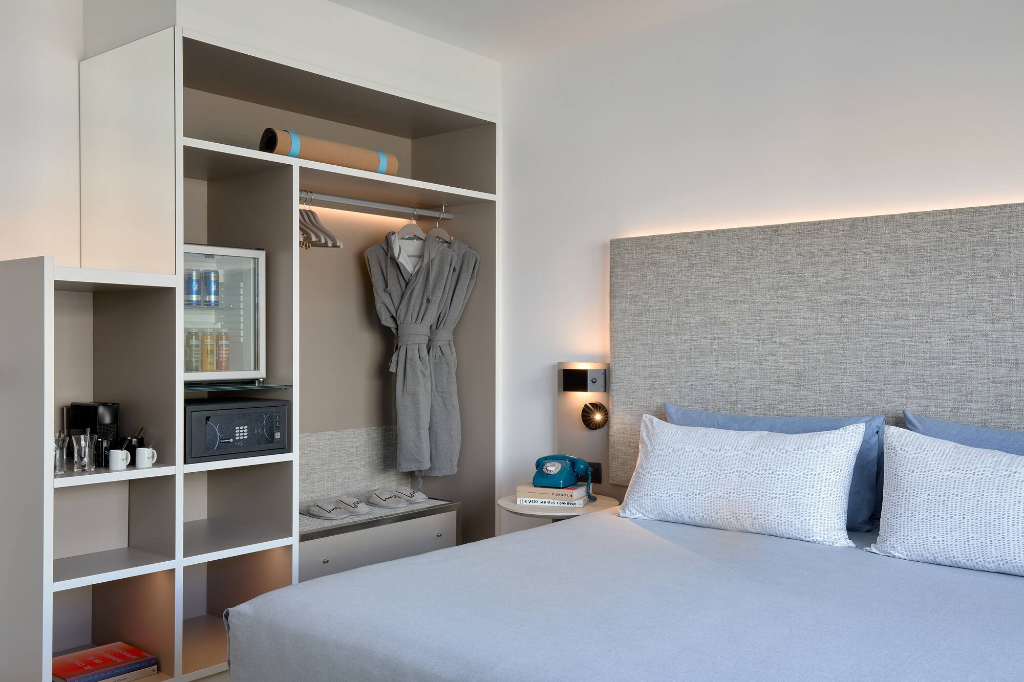 Hotel room with built-in storage, mini-bar, coffee maker, and comfy bed.