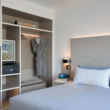 a bed with a white headboard and a shelf with a towel on it