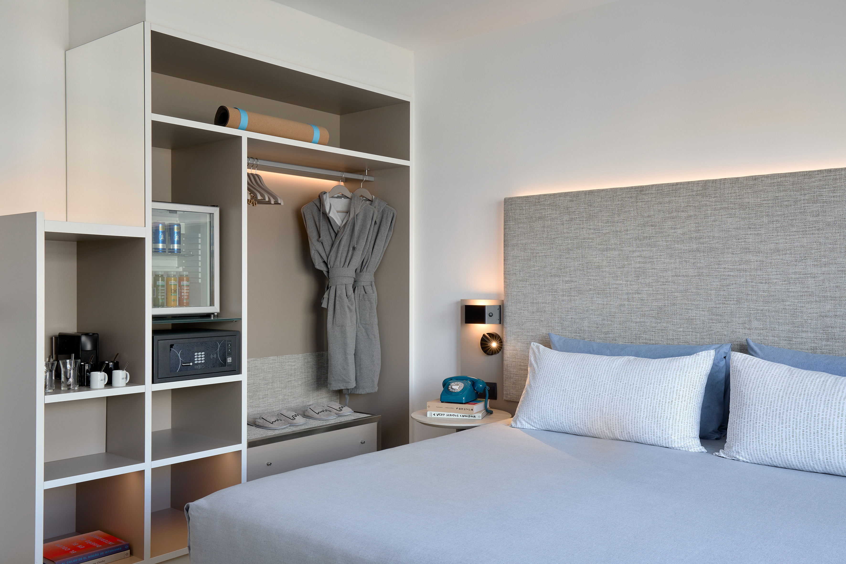 Hotel room with built-in storage, mini-bar, coffee maker, and comfy bed.