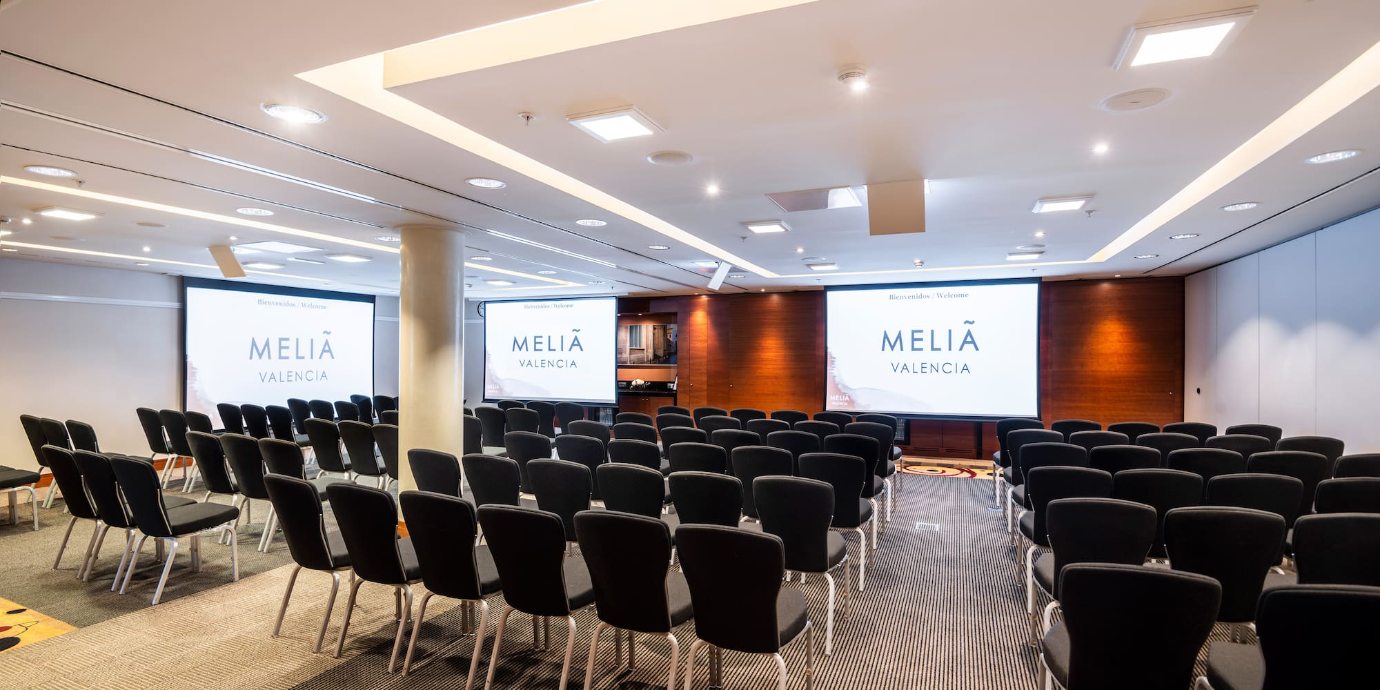 a room with chairs and projector screens