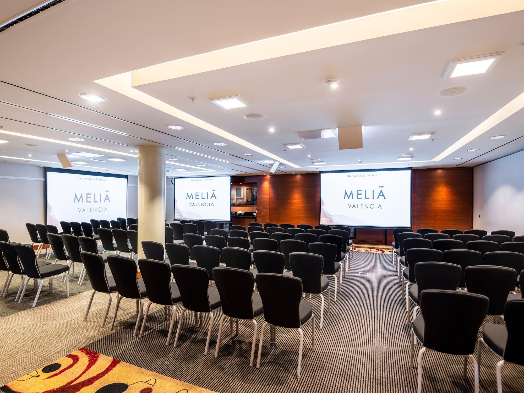 a room with chairs and projector screens