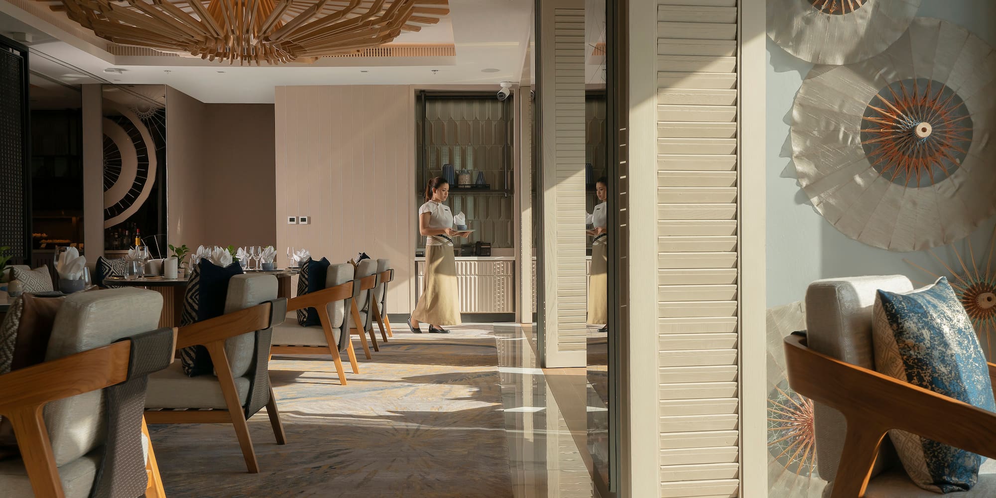 a woman standing in a room with chairs and a table