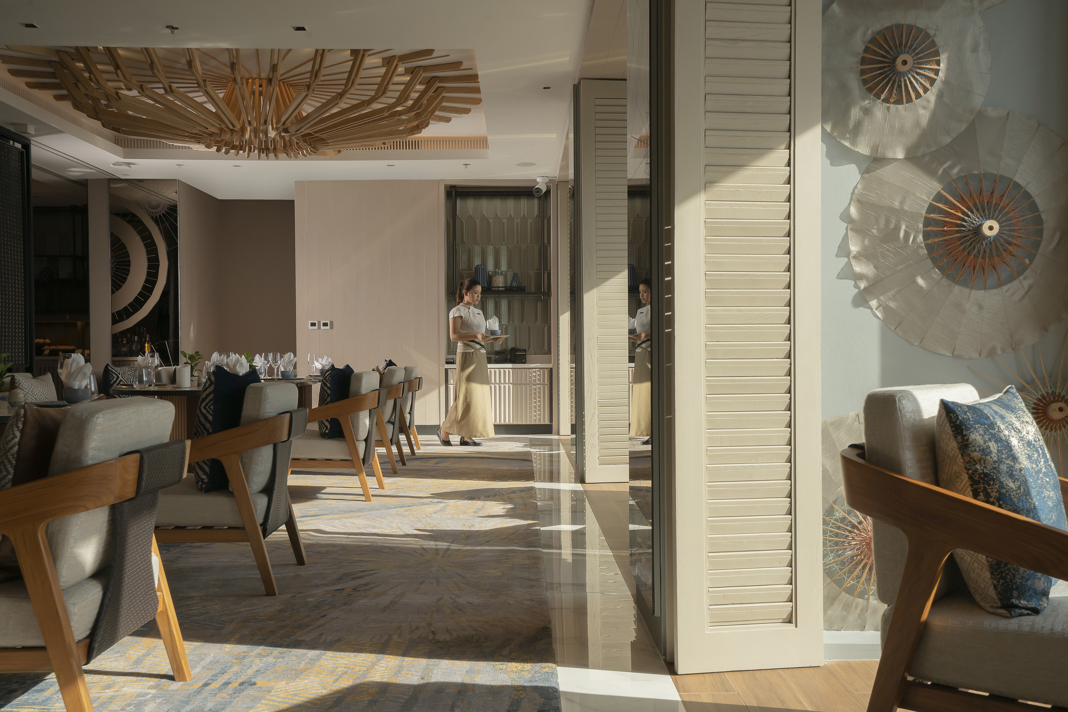 Modern elegant restaurant interior with a waitress and wooden decor.