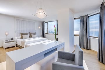 a room with two beds and a table with chairs and a flower in the vase
