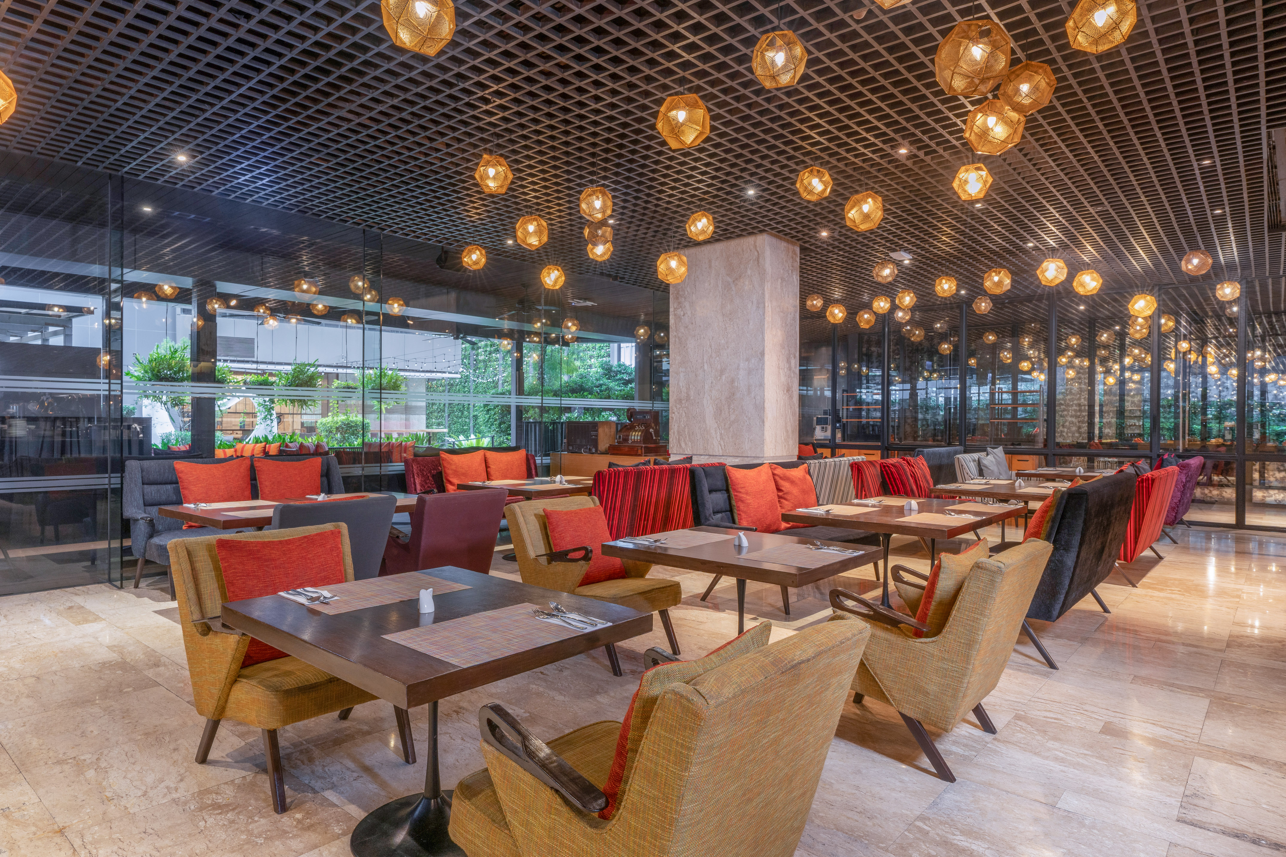 Modern restaurant interior with chic armchairs, dark wood tables, and a grid ceiling with pendant lights. - Dee Lite Bistro, المطبخ العالمي - The Hotel Bangkok Sukhumvit 26 Affiliated by Meliá, بانكوك