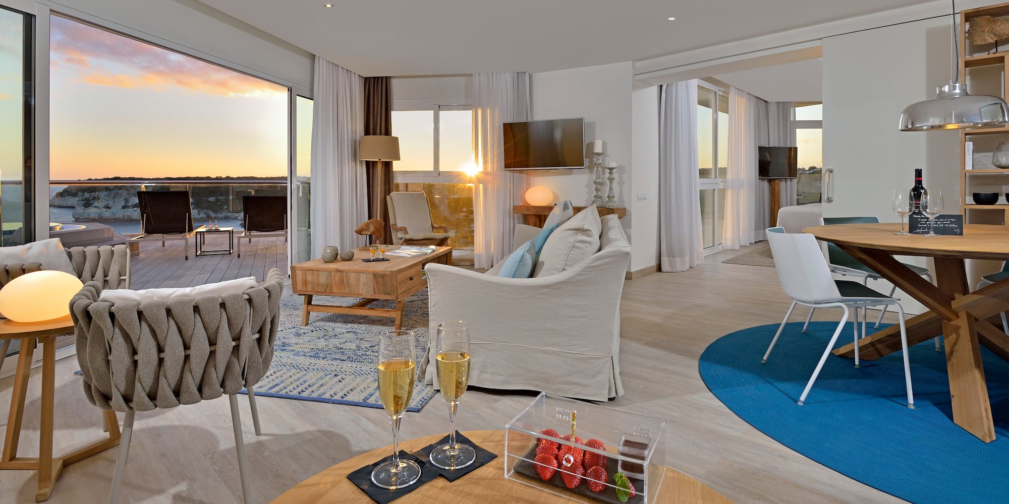 a room with a couch and a table with wine glasses