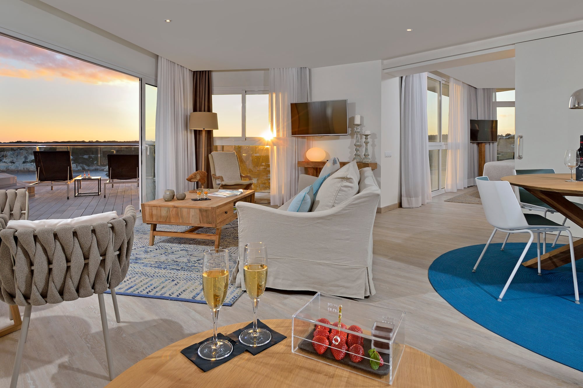 a room with a couch and a table with wine glasses