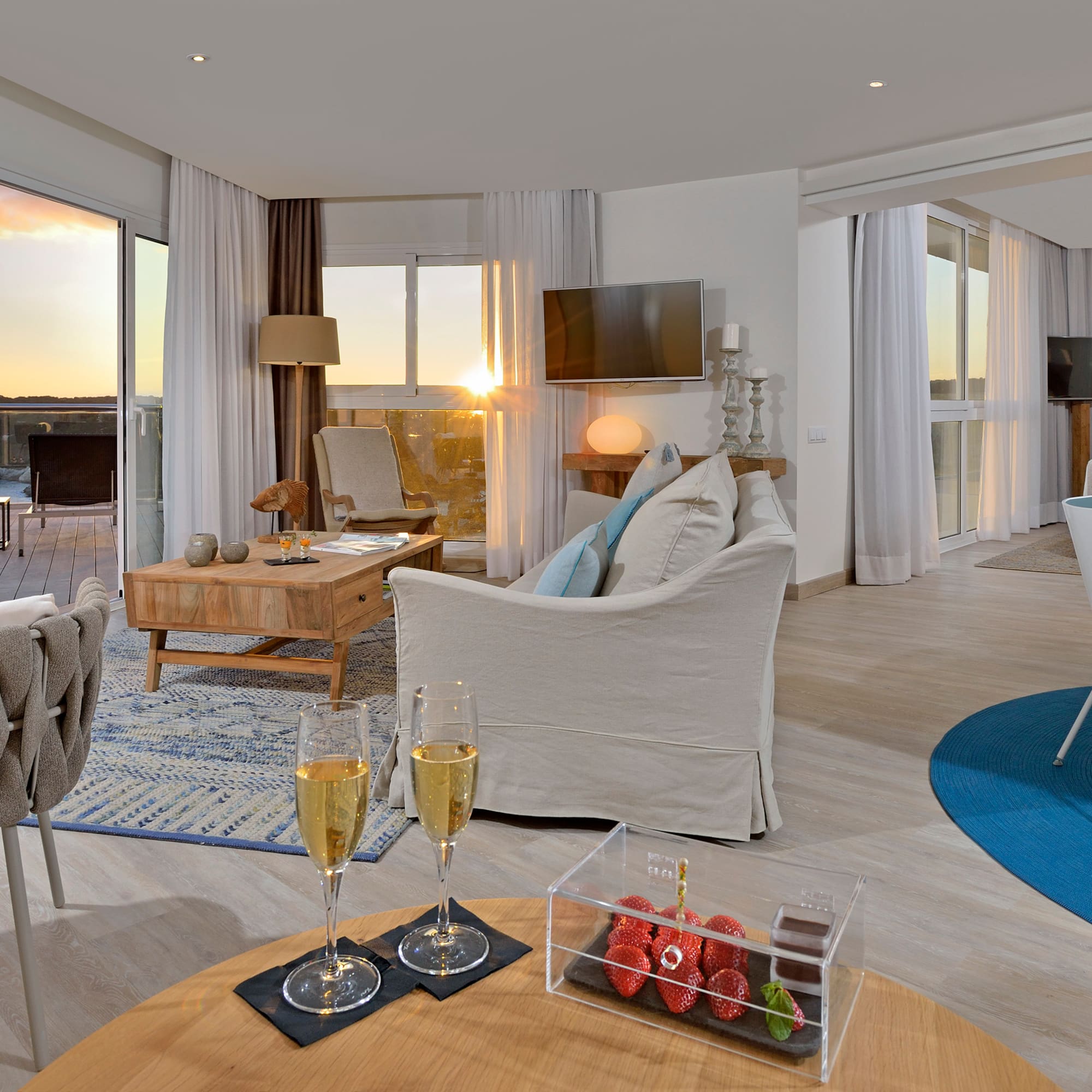 a room with a couch and a table with wine glasses