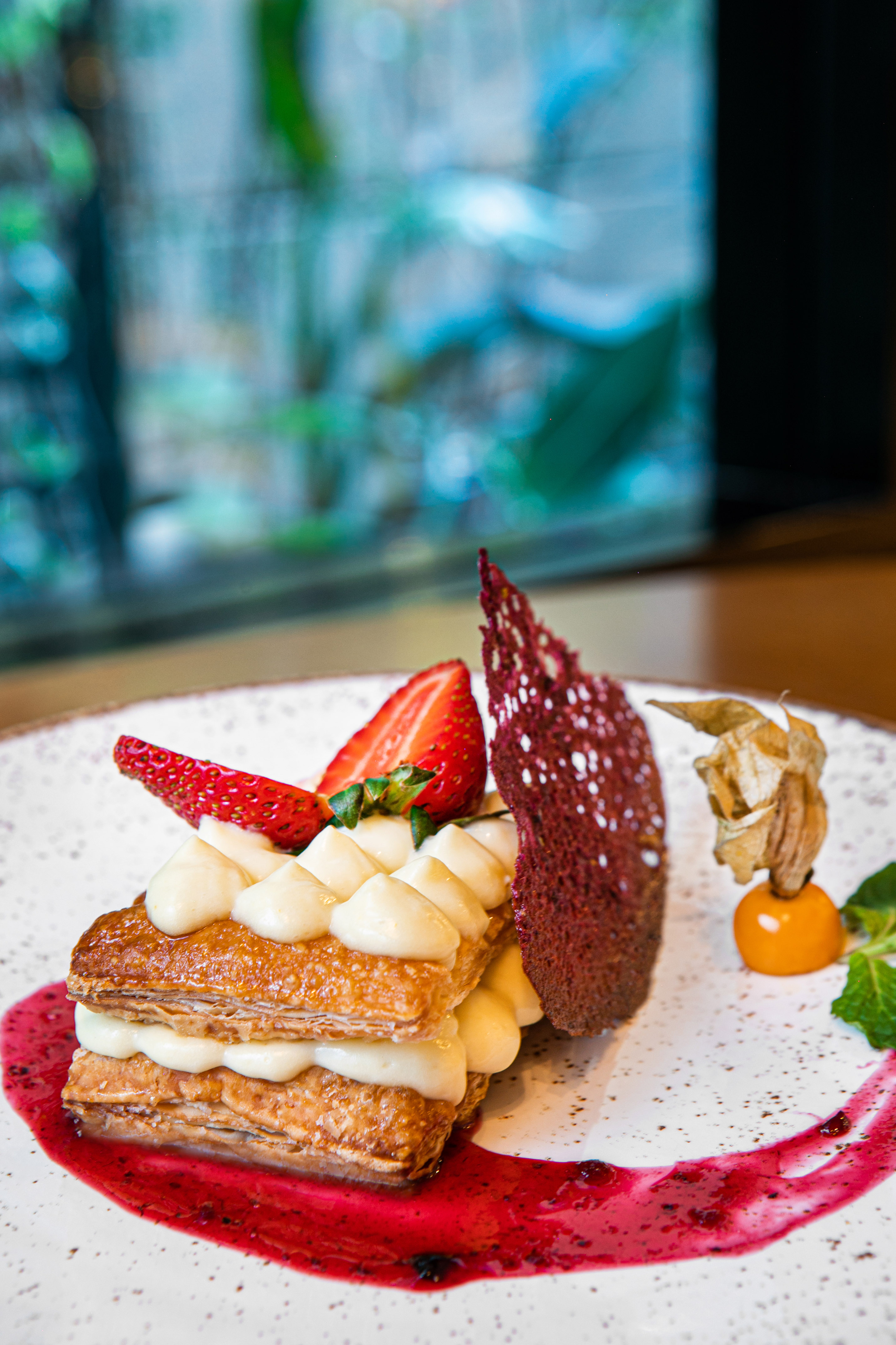Gourmet mille-feuille with cream, fresh strawberries, berry coulis, goldenberry.