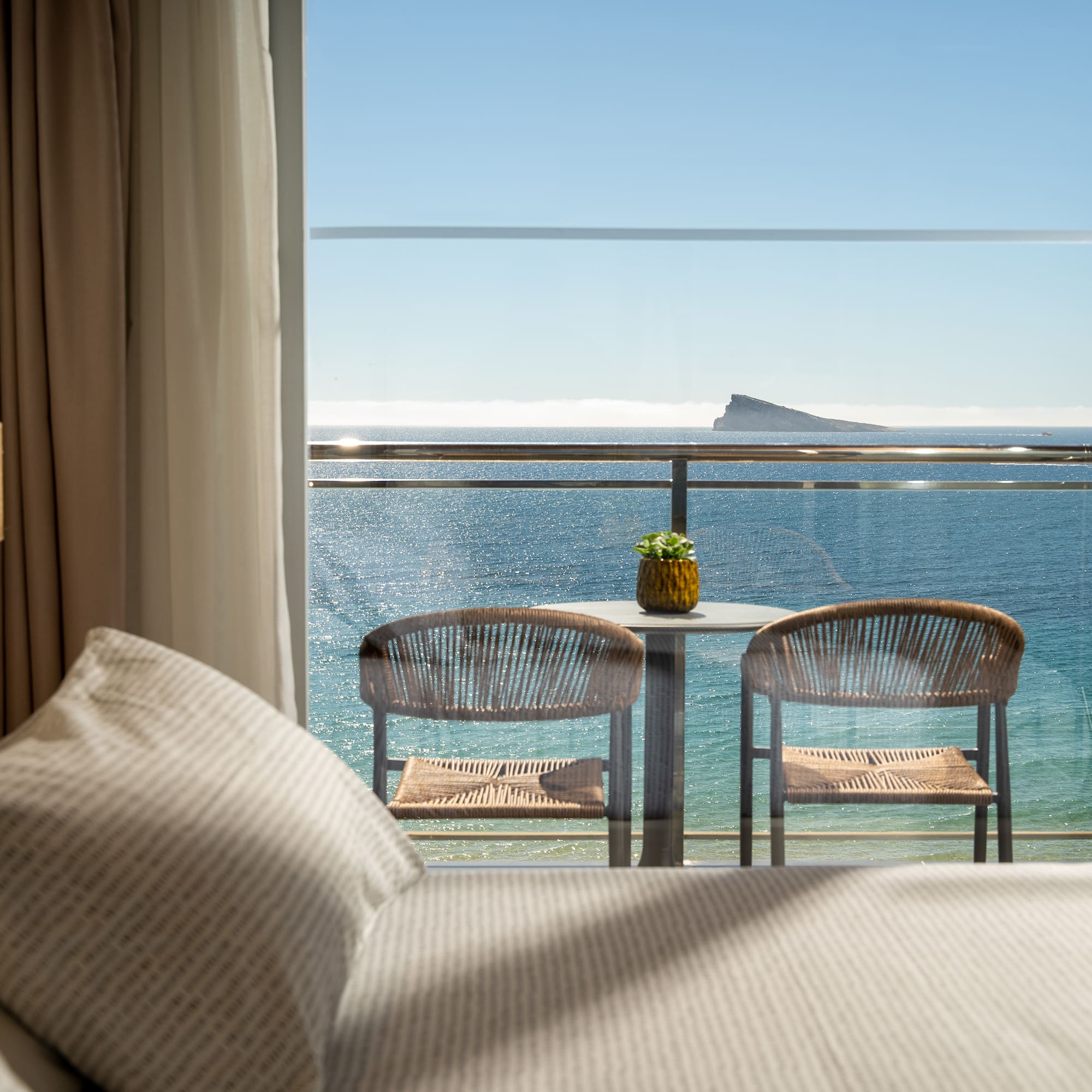 a room with a view of the ocean and a table and chairs
