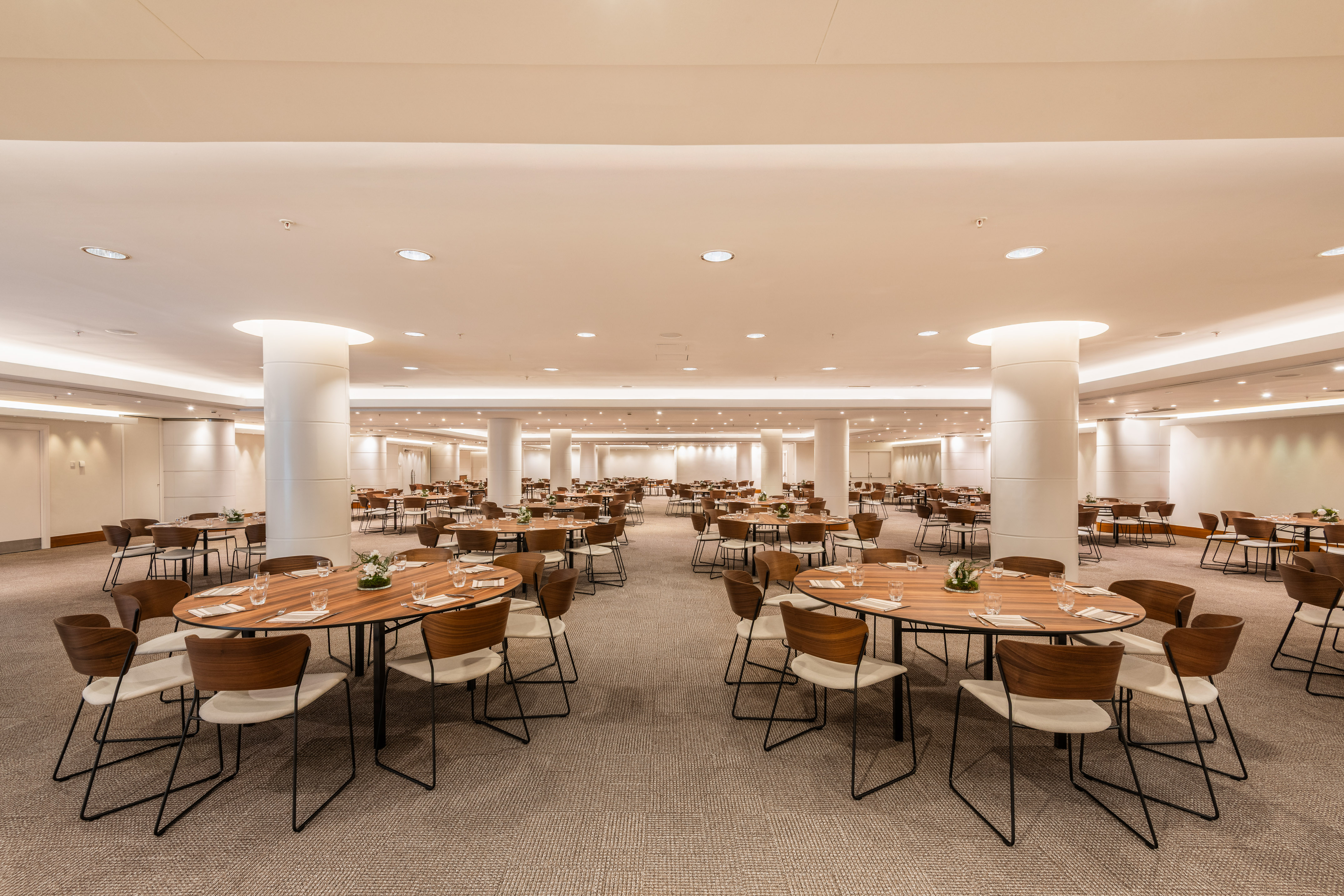 Spacious conference and event room with round tables and modern chairs.