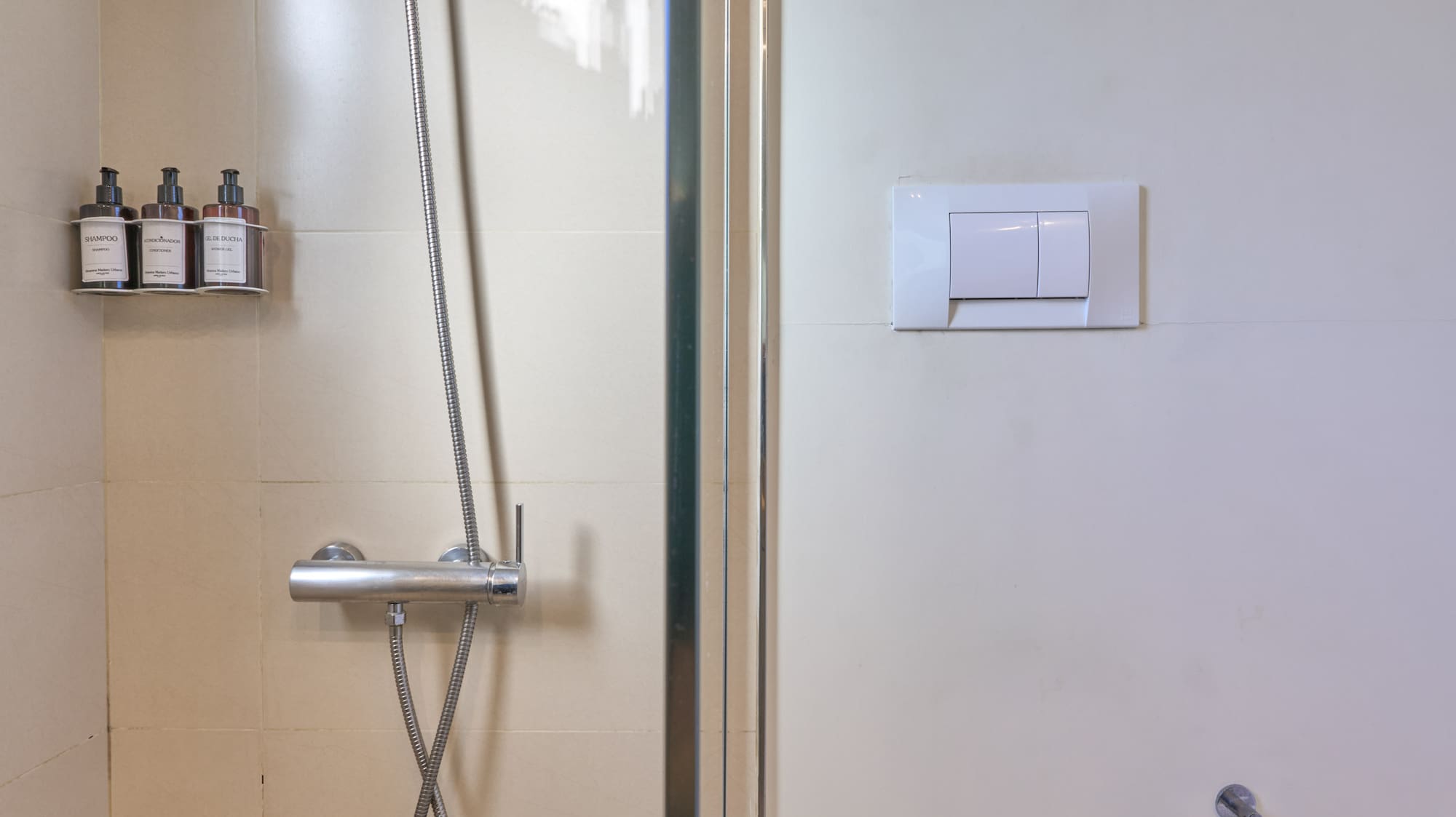 Clean tiled bathroom with glass shower and white toilet.