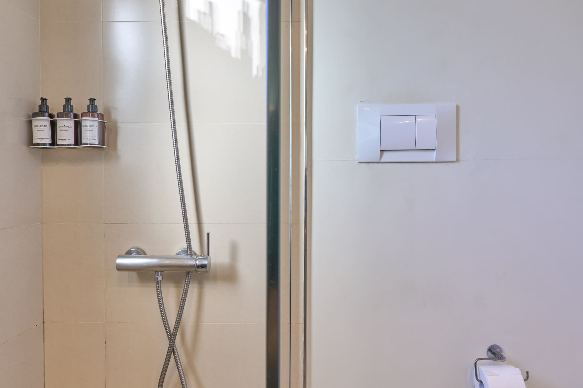 Clean tiled bathroom with glass shower and white toilet.