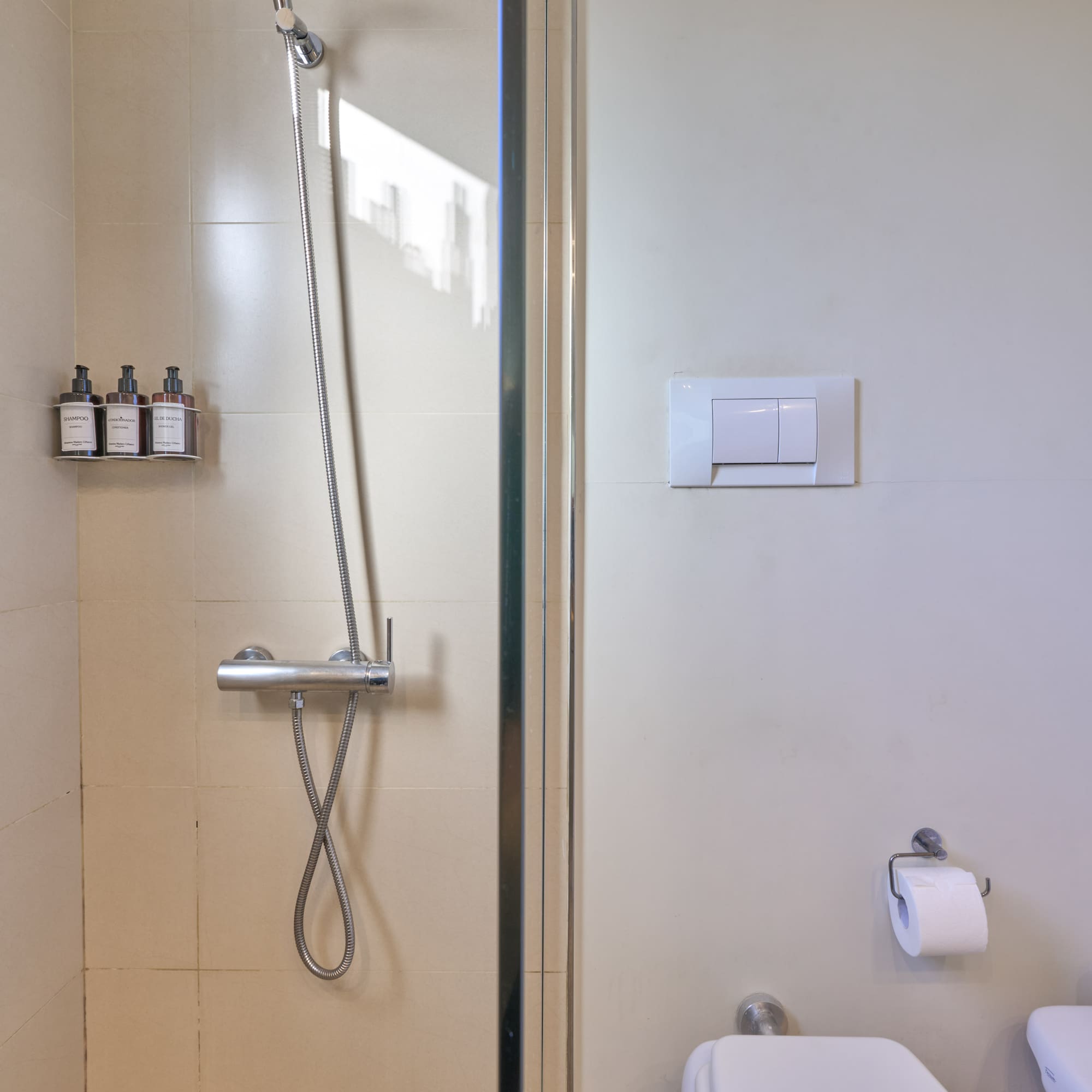 Clean tiled bathroom with glass shower and white toilet.