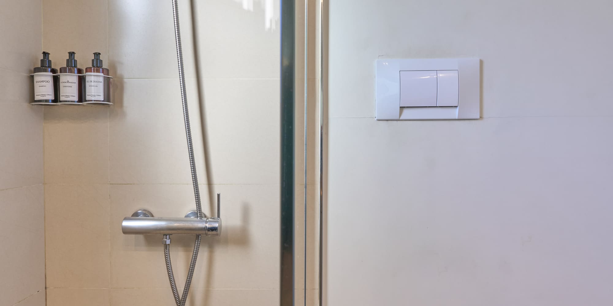 Clean tiled bathroom with glass shower and white toilet.