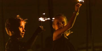 a couple of children holding sparklers at night