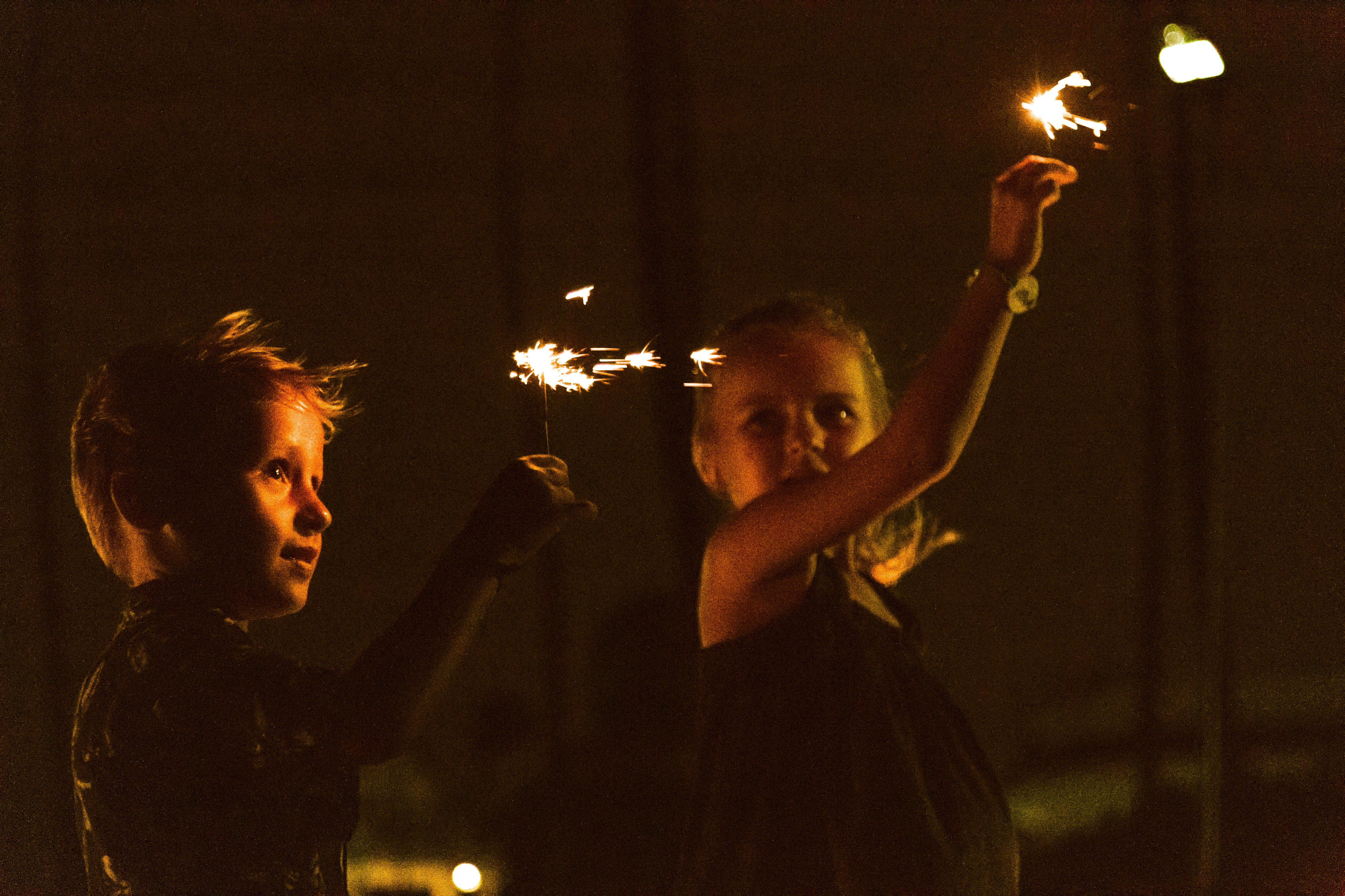 a couple of children holding sparklers at night