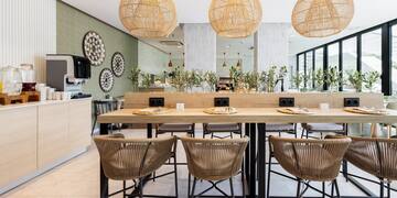 a dining table with chairs and wicker lamps