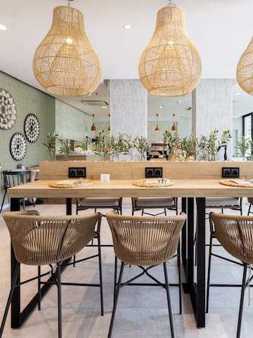 a dining table with chairs and wicker lamps