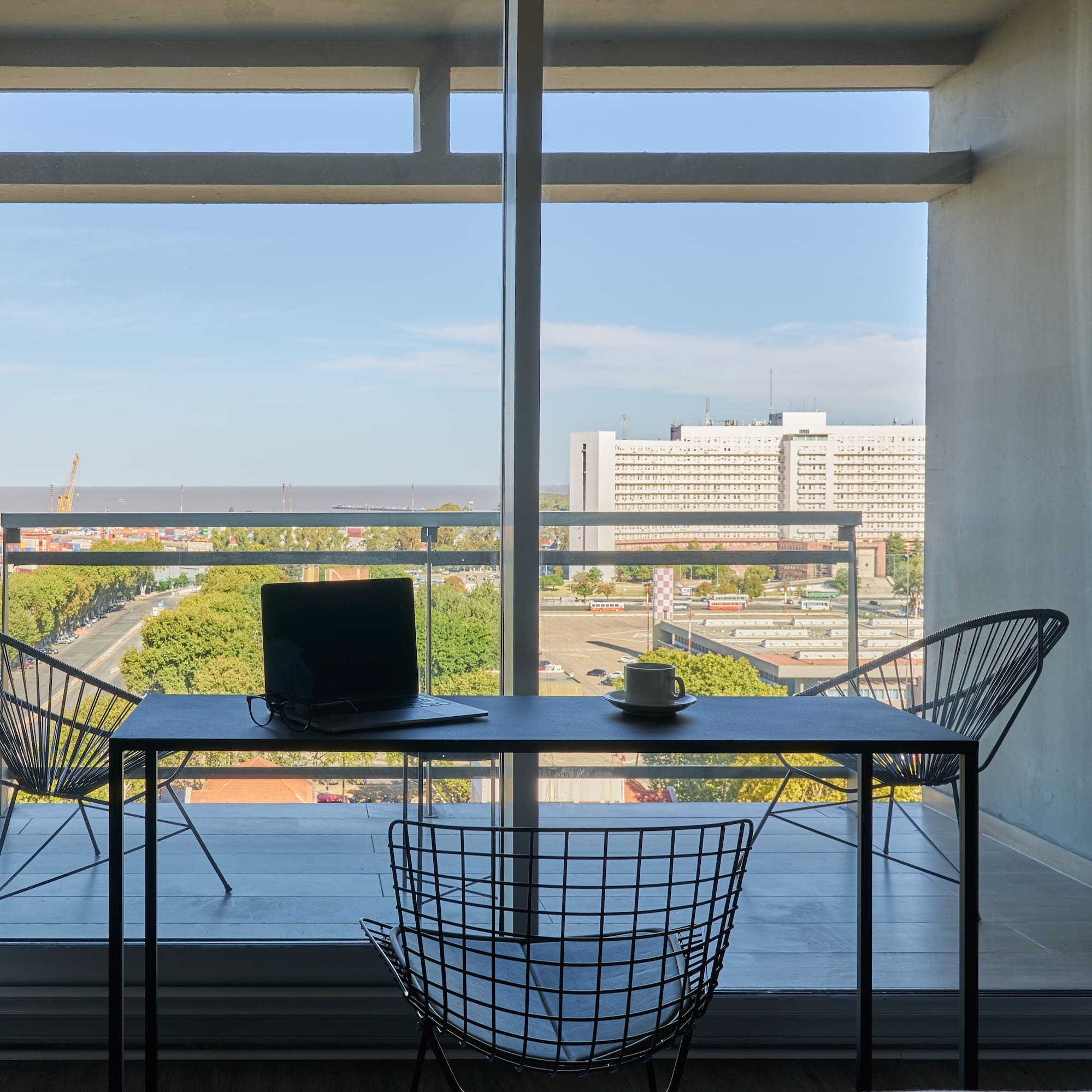 a table and chairs in a room with a view of a city
