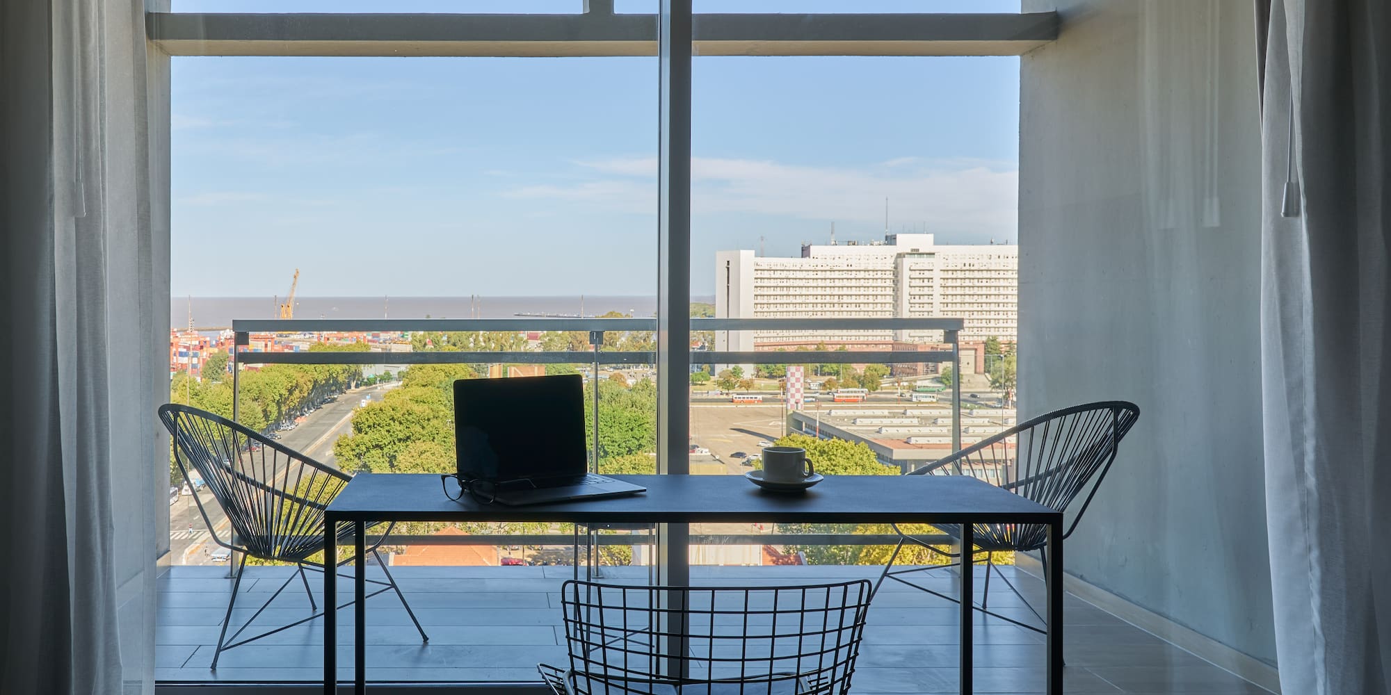 a table and chairs in a room with a view of a city
