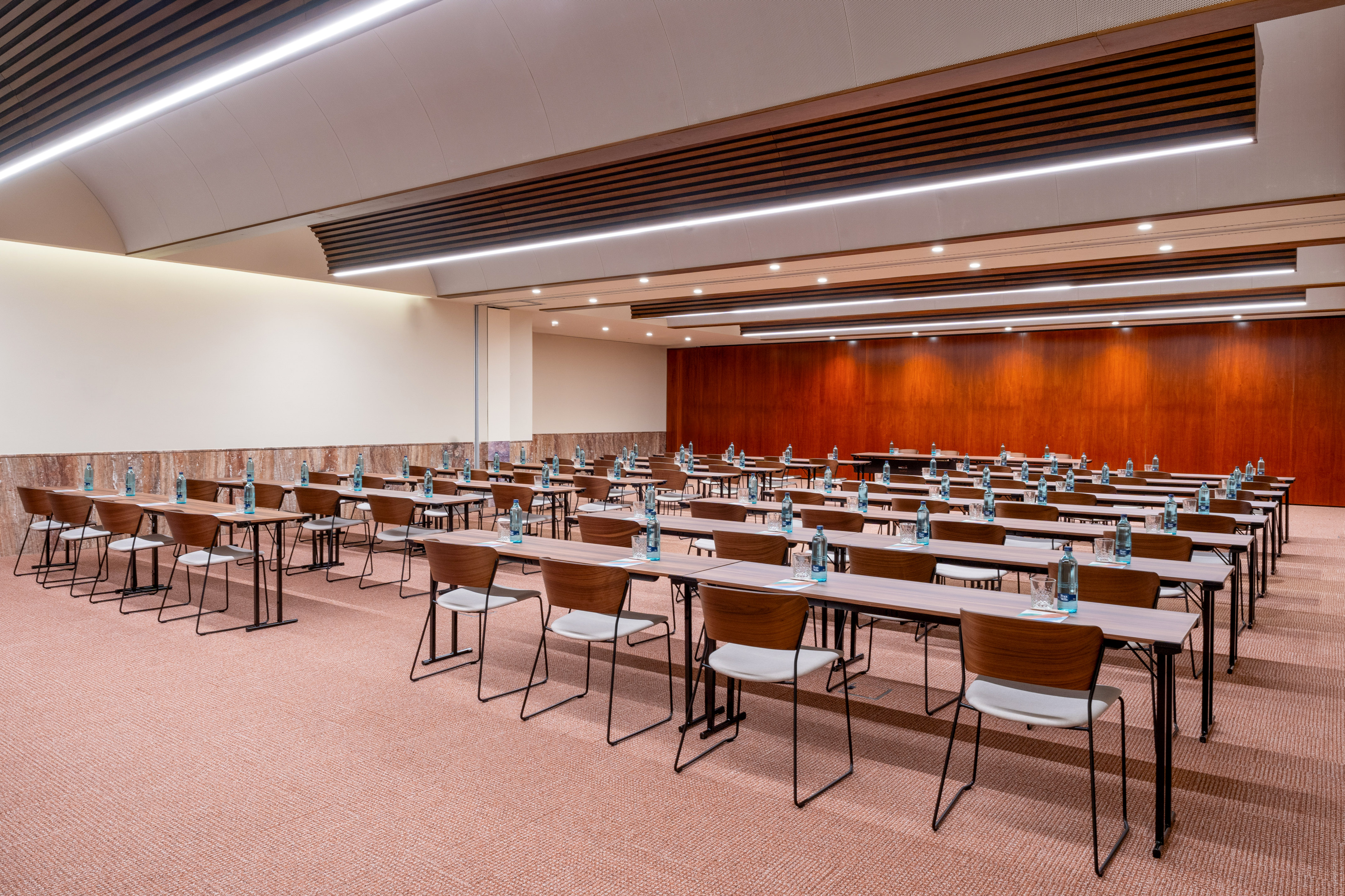 Spacious conference room with classroom setup, tables, chairs, and water bottles.