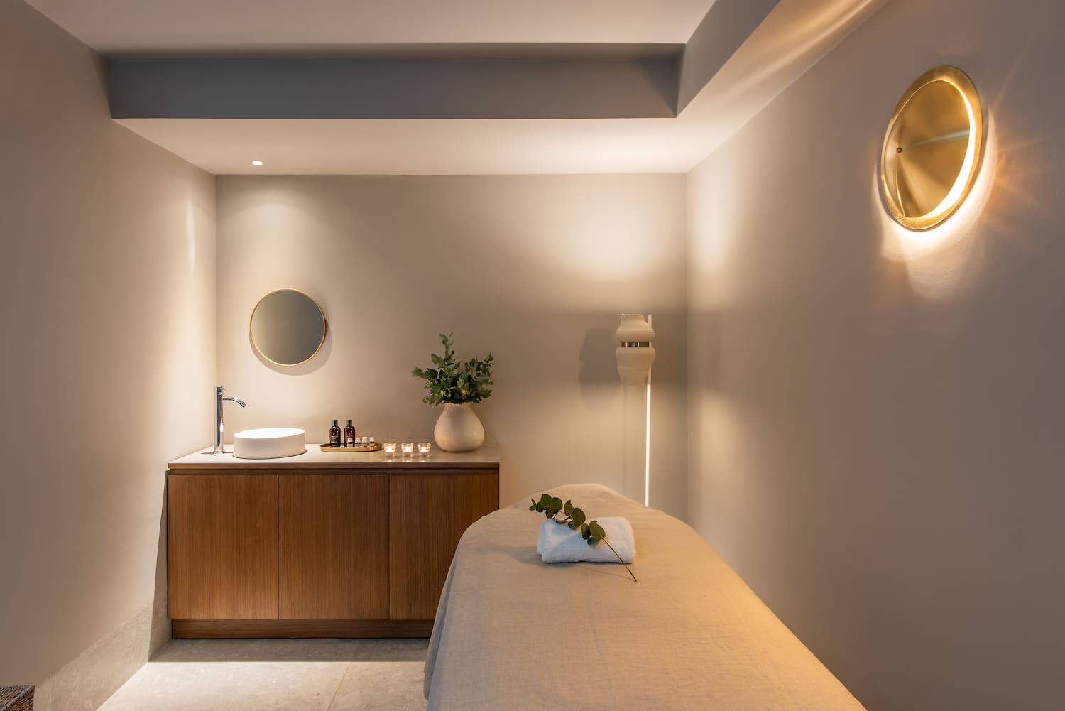 a massage room with a sink and a mirror