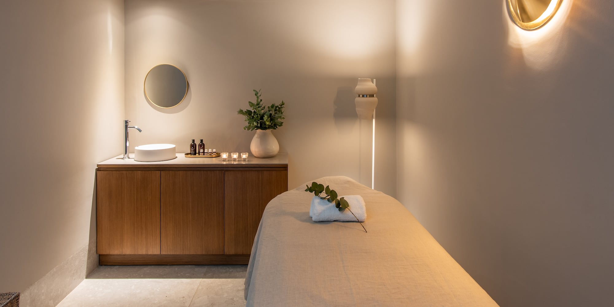 a massage room with a sink and a mirror