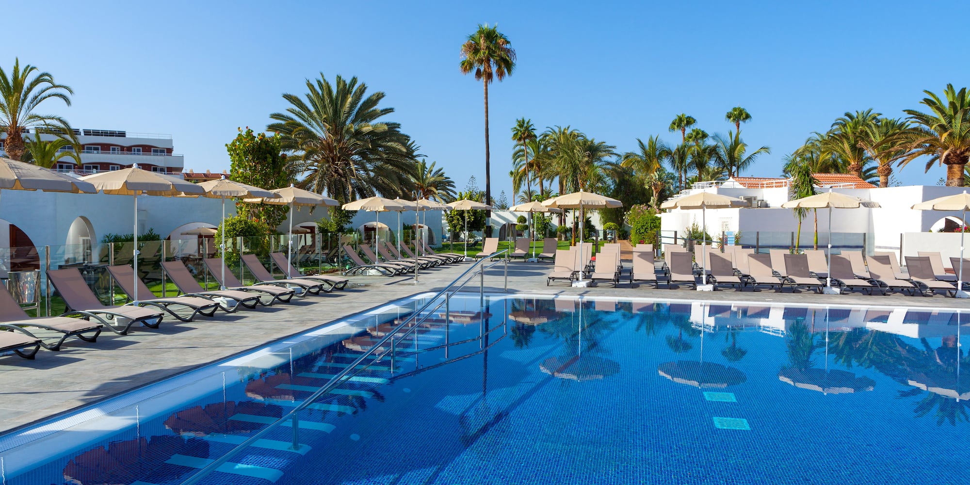a pool with lounge chairs and umbrellas