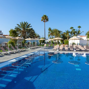a pool with lounge chairs and umbrellas