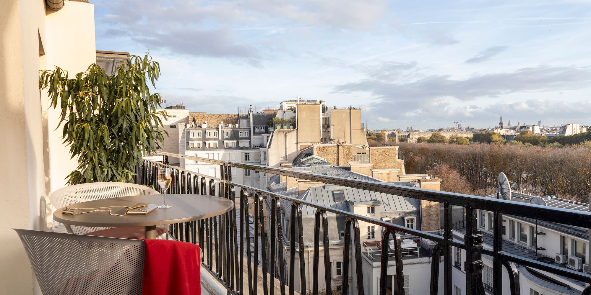 a table and chair on a balcony with a view of a city