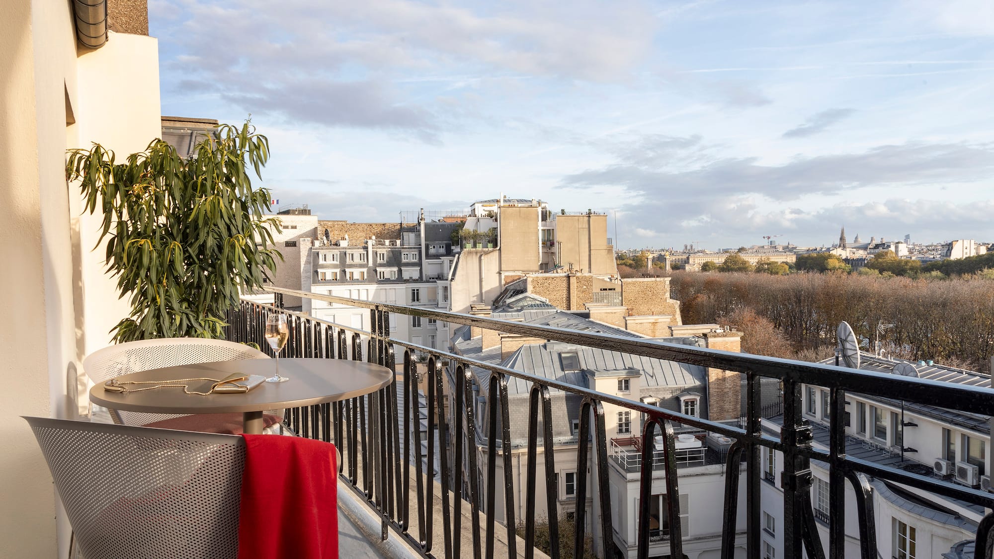 a table and chair on a balcony with a view of a city