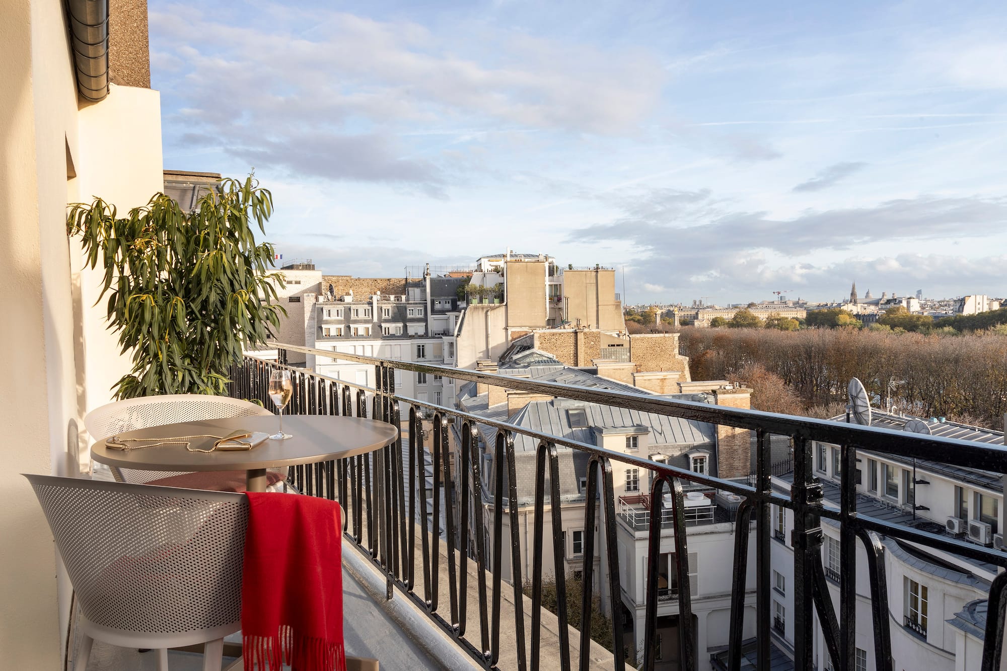 a table and chair on a balcony with a view of a city