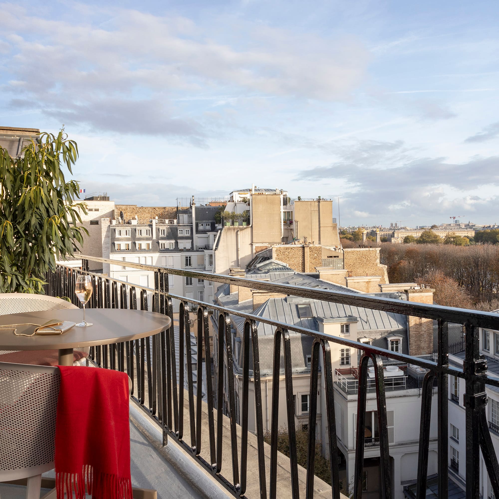 a table and chair on a balcony with a view of a city