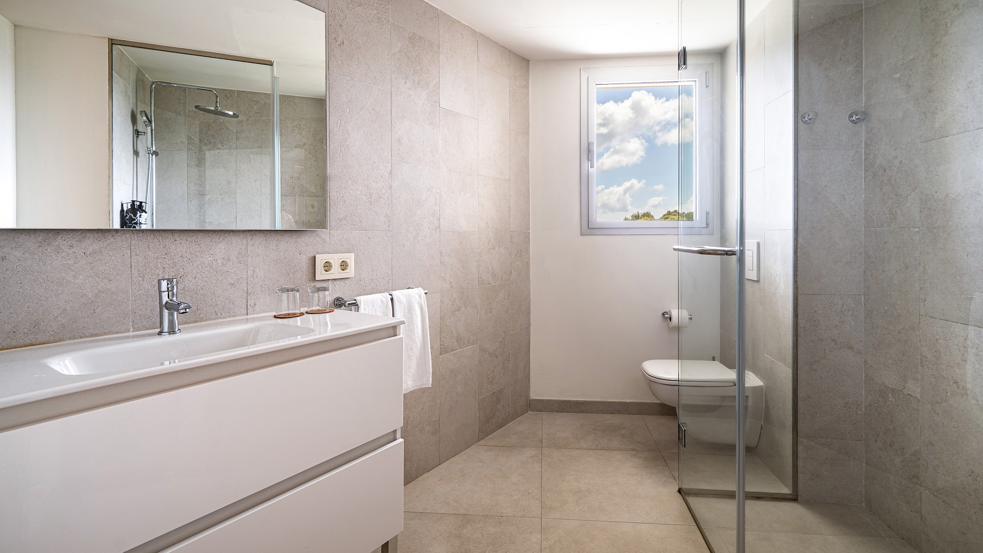 a bathroom with a glass shower door and sink