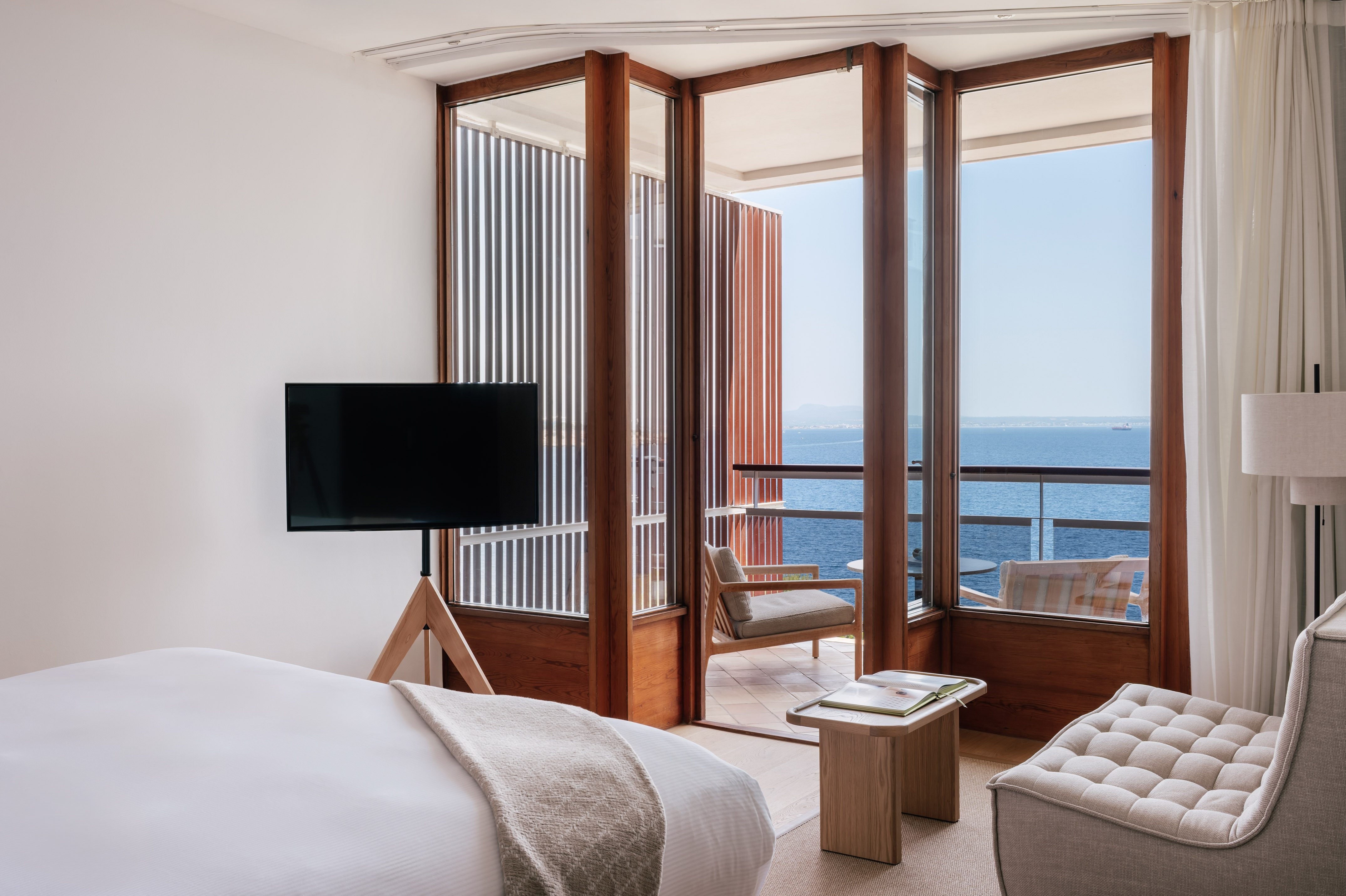 a room with a television and a view of the ocean