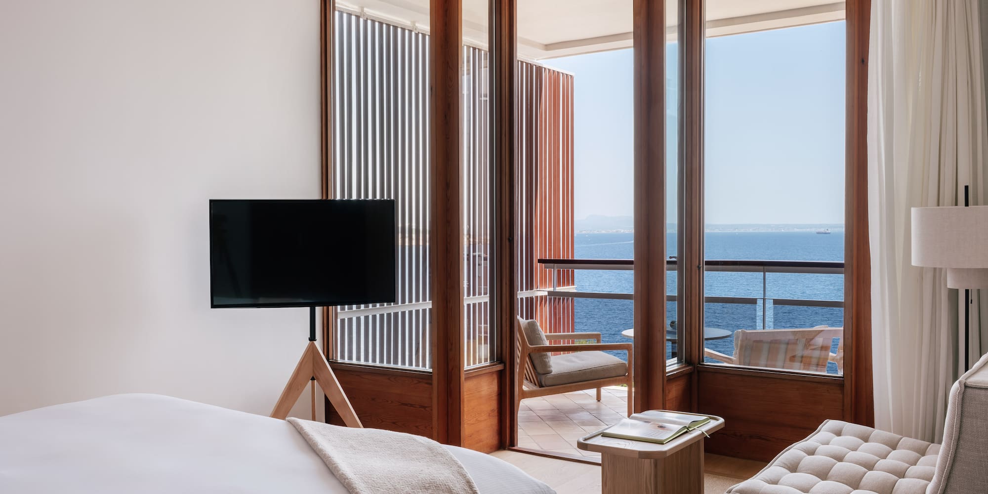 a room with a television and a view of the ocean