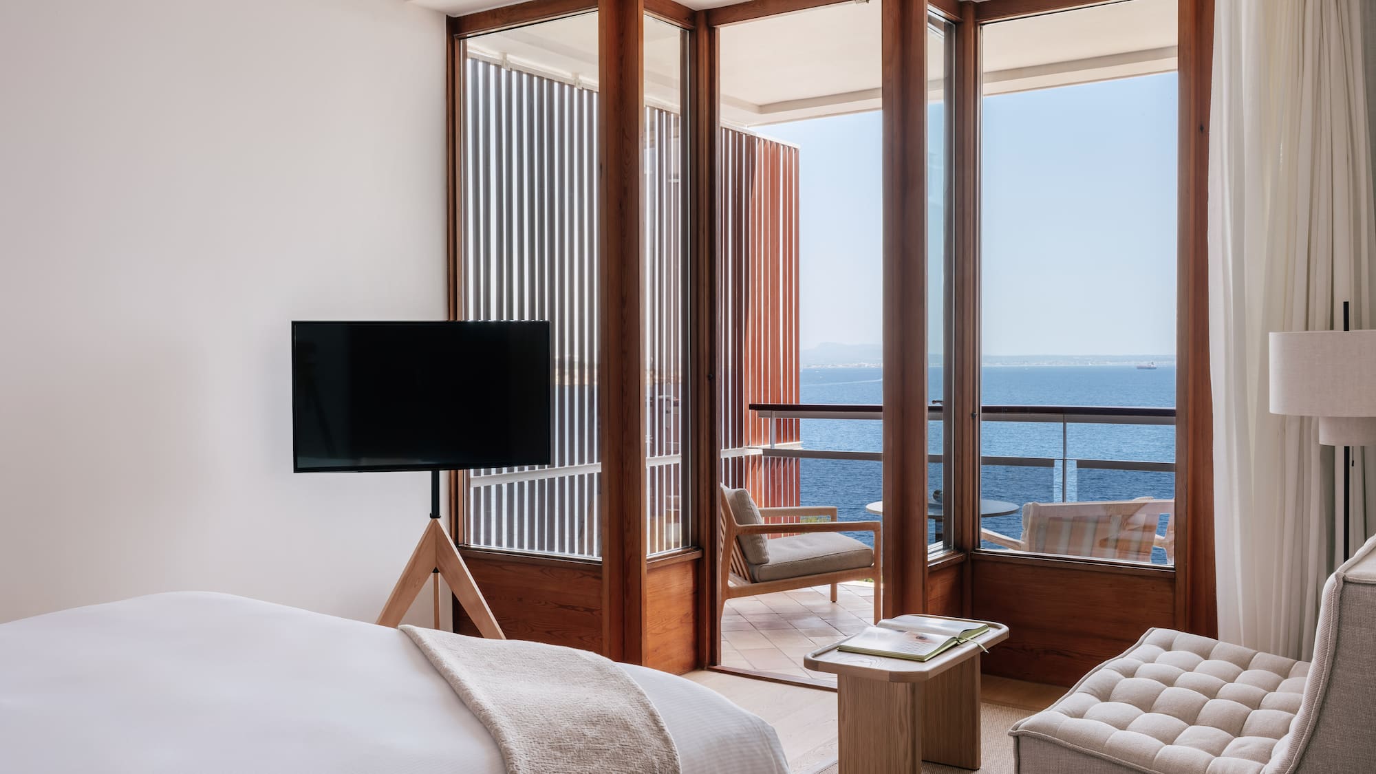 a room with a television and a view of the ocean