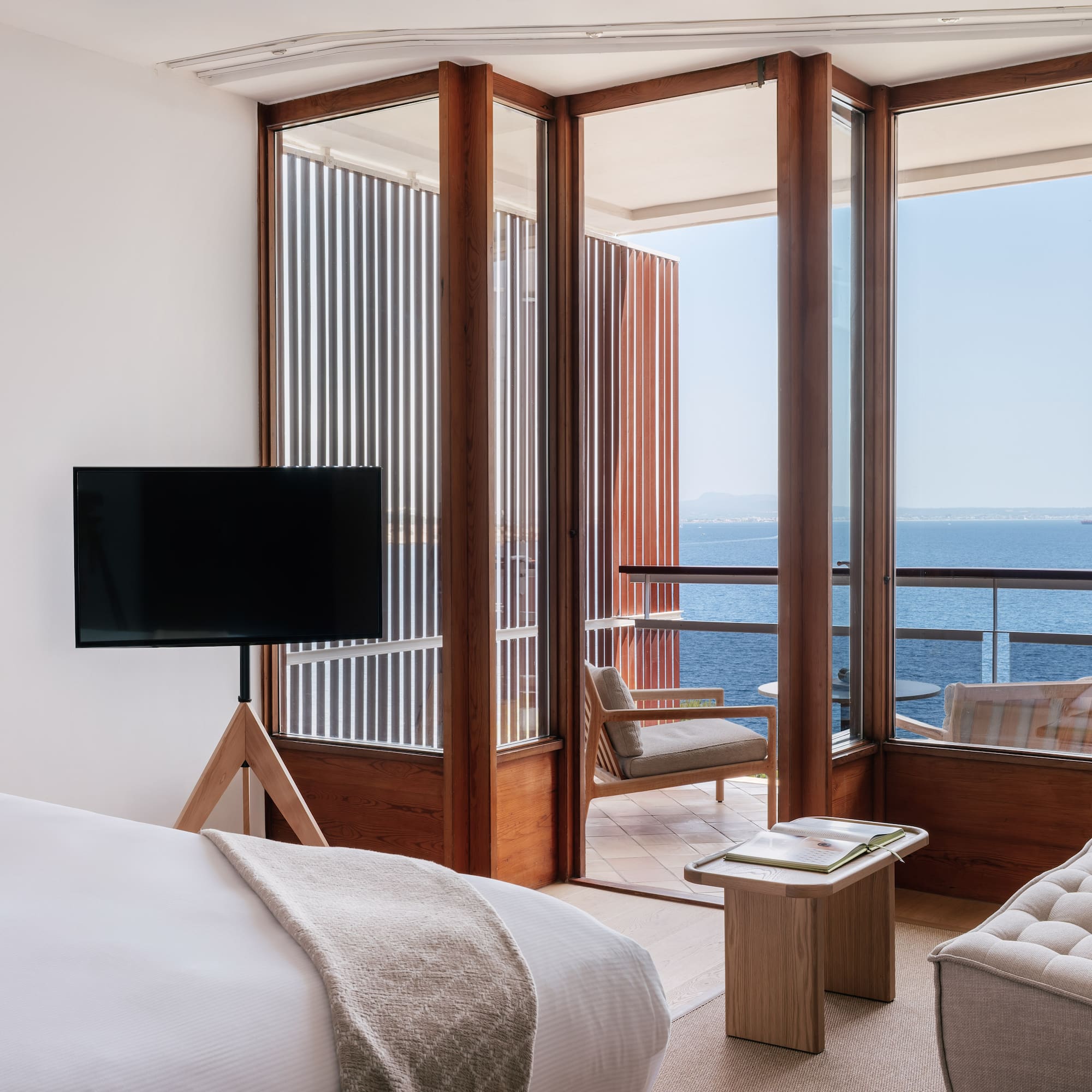 a room with a television and a view of the ocean