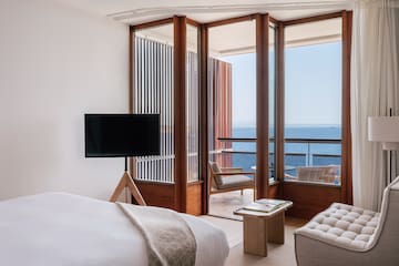 a room with a television and a view of the ocean