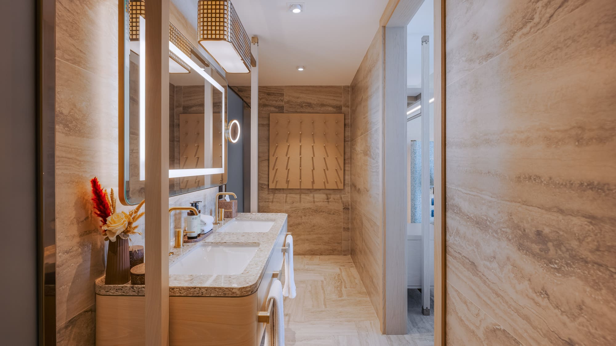 Luxury double vanity bathroom with illuminated mirrors and stone walls.