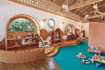 a room with a large playroom with a blue carpet and toys