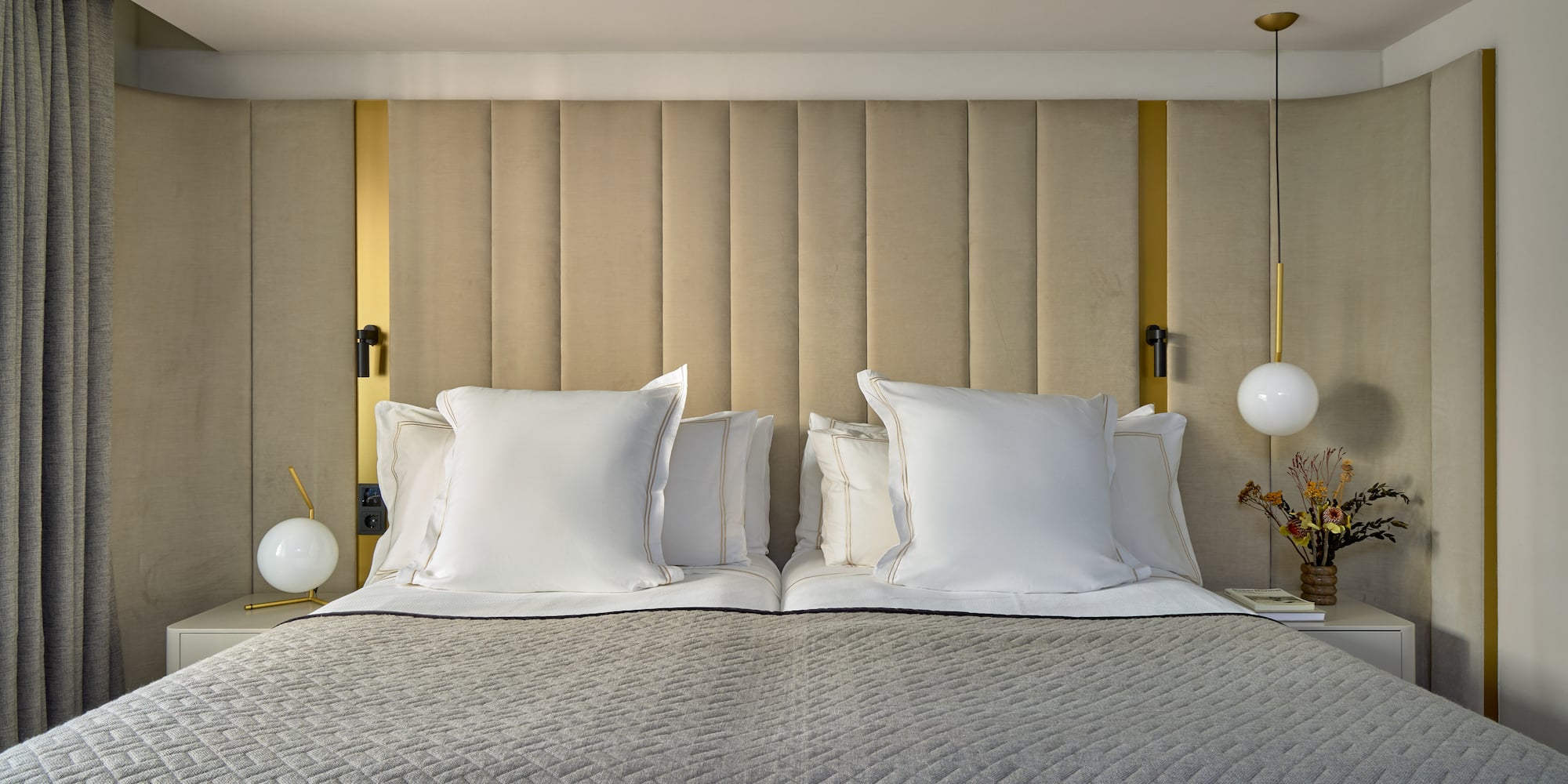 a bed with pillows and lamps