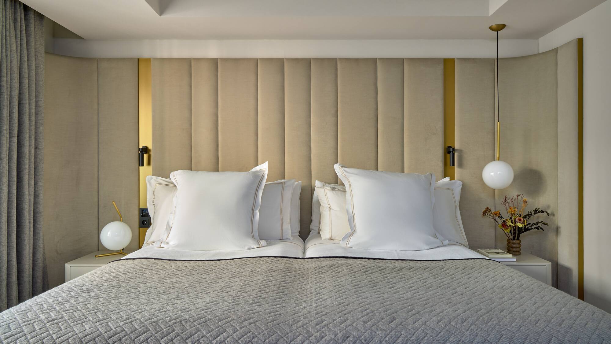 a bed with pillows and lamps