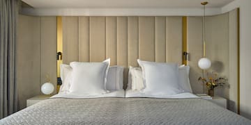 a bed with pillows and lamps