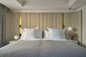 a bed with pillows and lamps