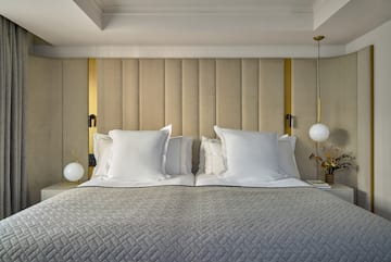 a bed with pillows and lamps