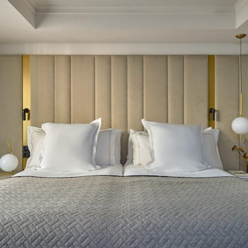 a bed with pillows and lamps
